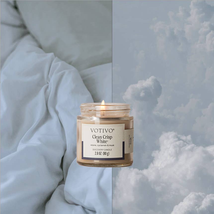 Votivo candle in a jar with a label on a textured fabric background