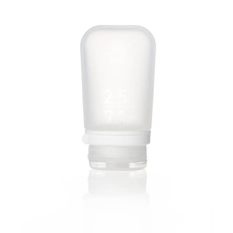 A collection of GoToob+ containers in various colors displayed with their caps off, showcasing the food-grade silicone body and the leakproof valve in the cap.