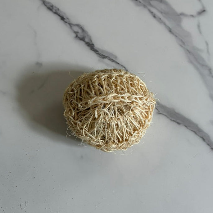 Sisal (agave fiber) Body Sponge for exfoliating on a marble surface