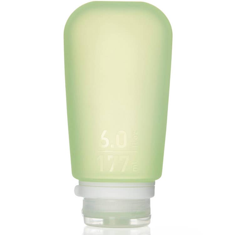 A collection of GoToob+ containers in various colors displayed with their caps off, showcasing the food-grade silicone body and the leakproof valve in the cap.