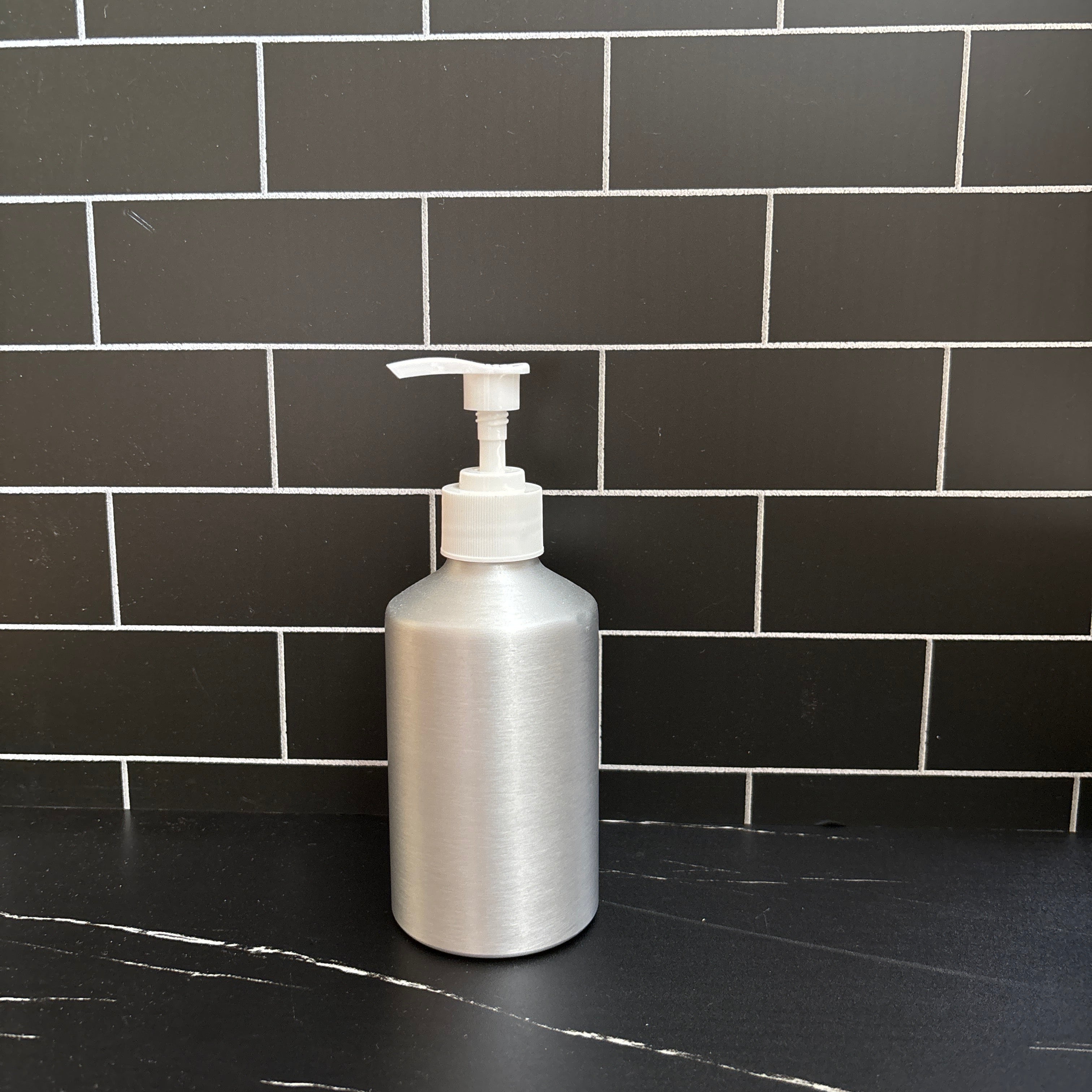 Aluminum bottle for soap dispenser black tiled wall refillable
