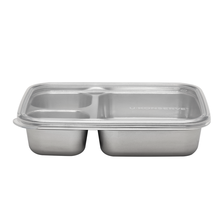 A stainless steel compartment food tray with a clear plastic lid, featuring two main sections and one smaller section on the left, with the brand name 'U-KONSERVET' printed on the lid.