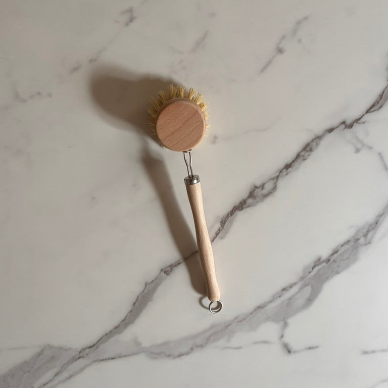 Kitchen brush with wooden handle on a marble surface