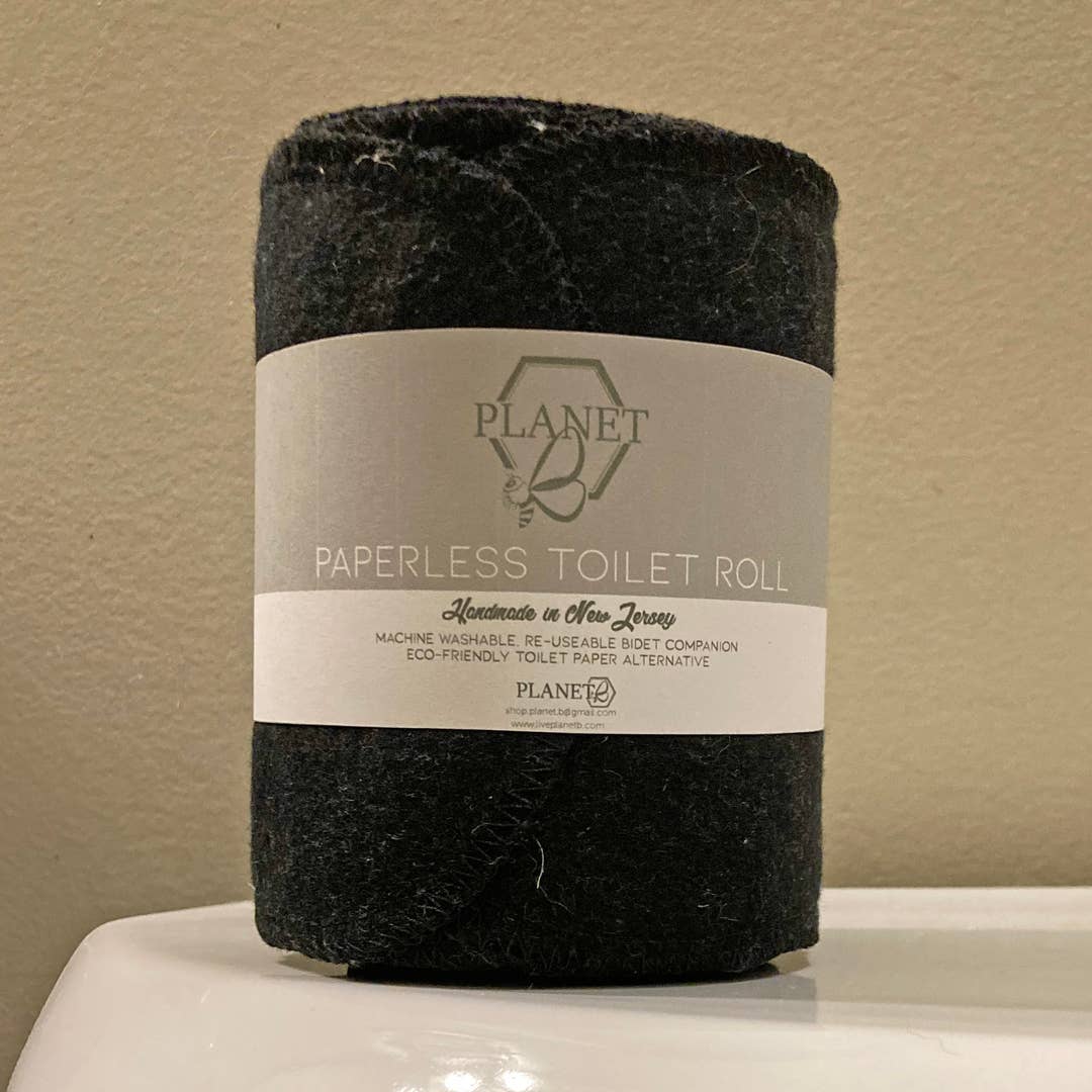 Black paperless toilet roll with a label on a beige background