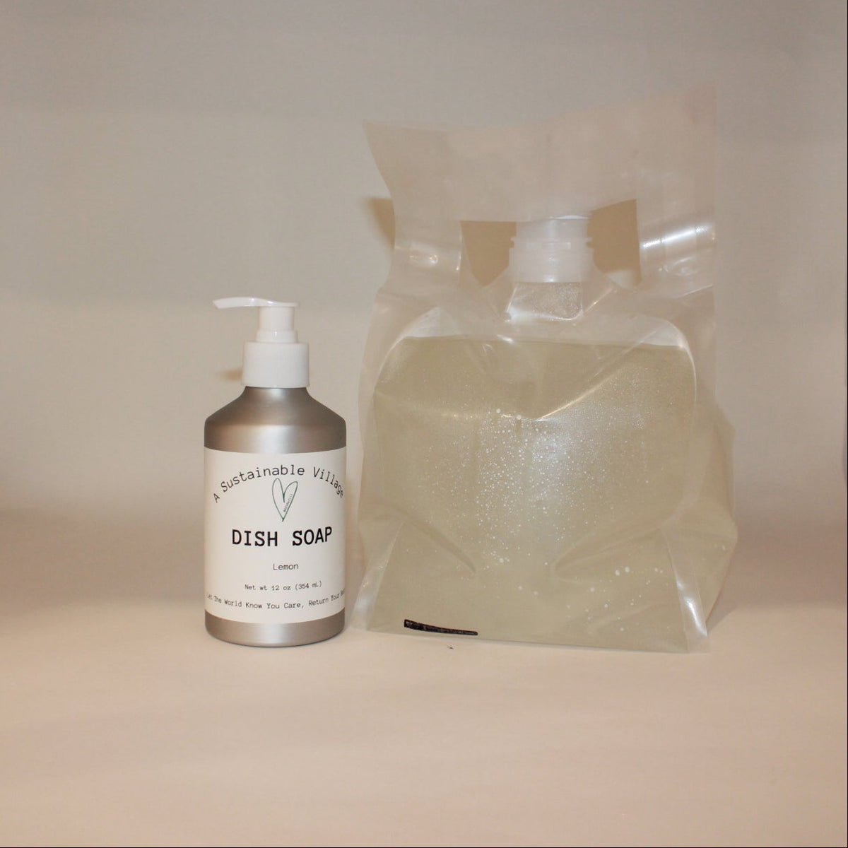 Bottle of dish soap and a bag of soap on a white surface with a wooden shelf in the background.