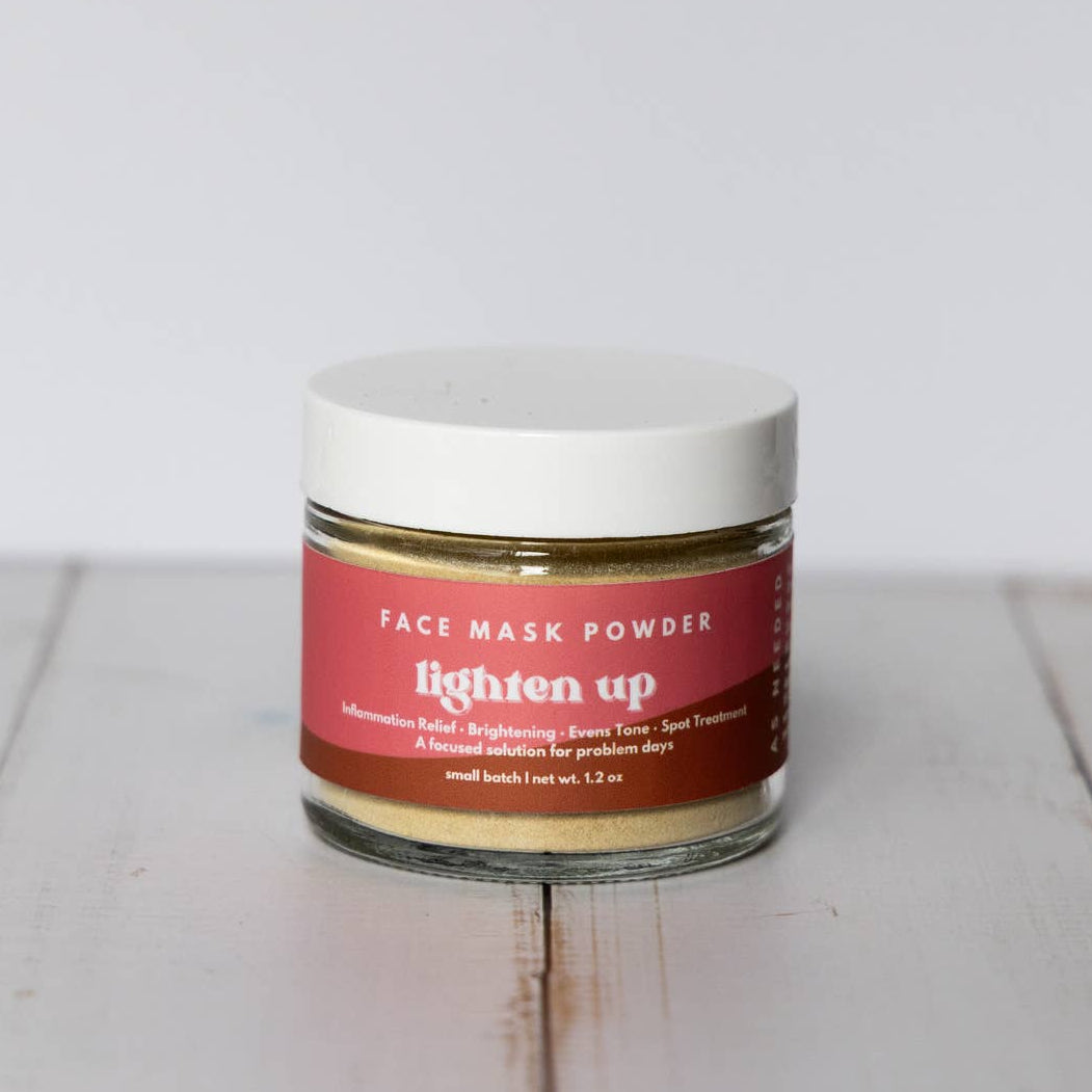 Jar of face mask powder with a red label on a wooden surface