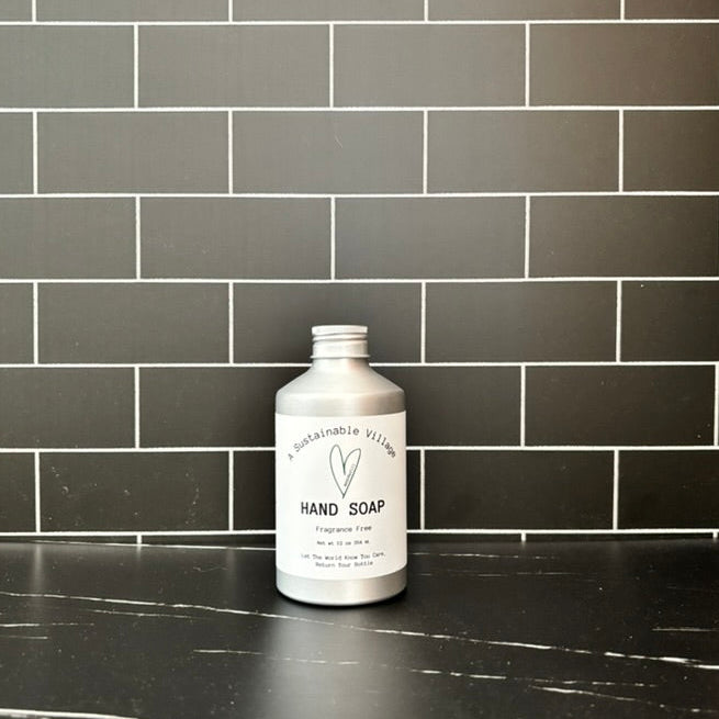 Hand soap aluminum bottle on a black tiled bathroom counter