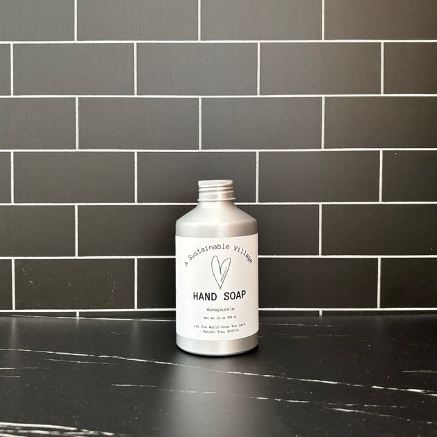 Aluminum Bottle hand soap bottle on a black tiled wall background