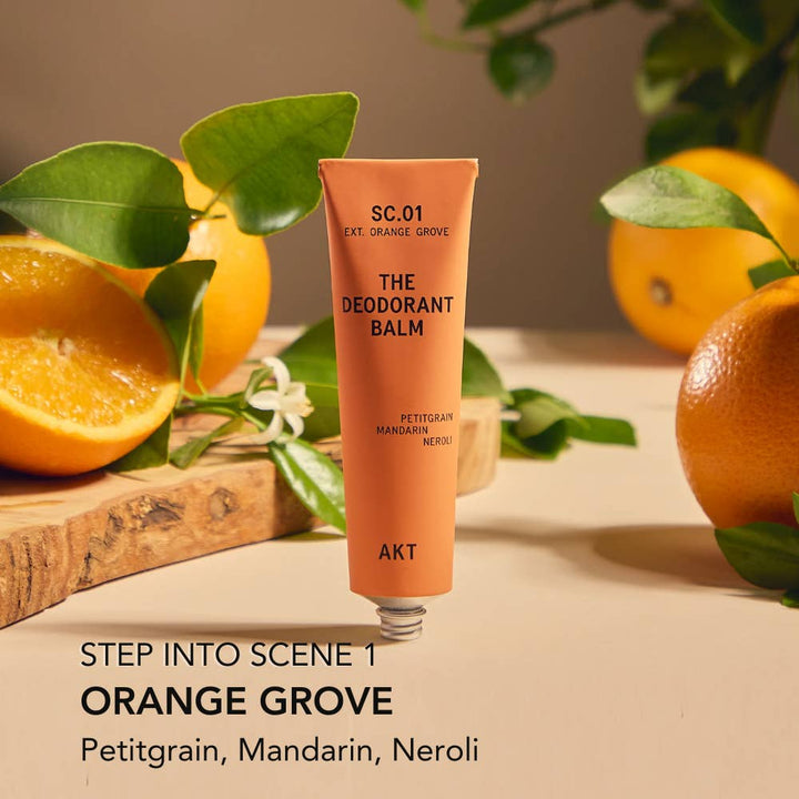 Deodorant balm tube with oranges and leaves on a wooden surface.  Plastic Free Zero Waste