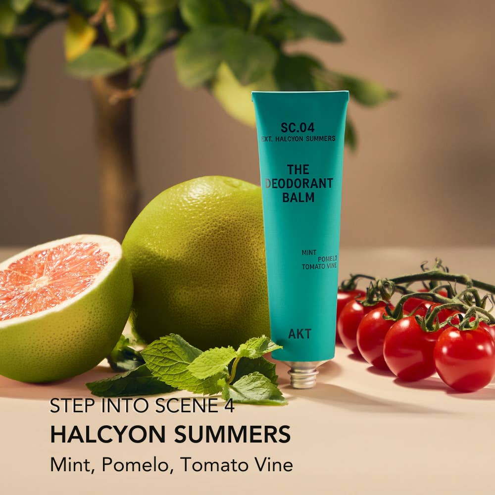 Blue deodorant balm tube labeled 'SC.04 THE DEODORANT BALM' with pomelo, grapefruit, and tomatoes on a neutral background. Plastic Free Zero waste