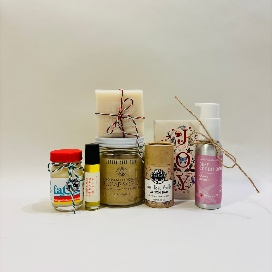 Collection of beauty products including candles, scrubs, and lotions on a white background