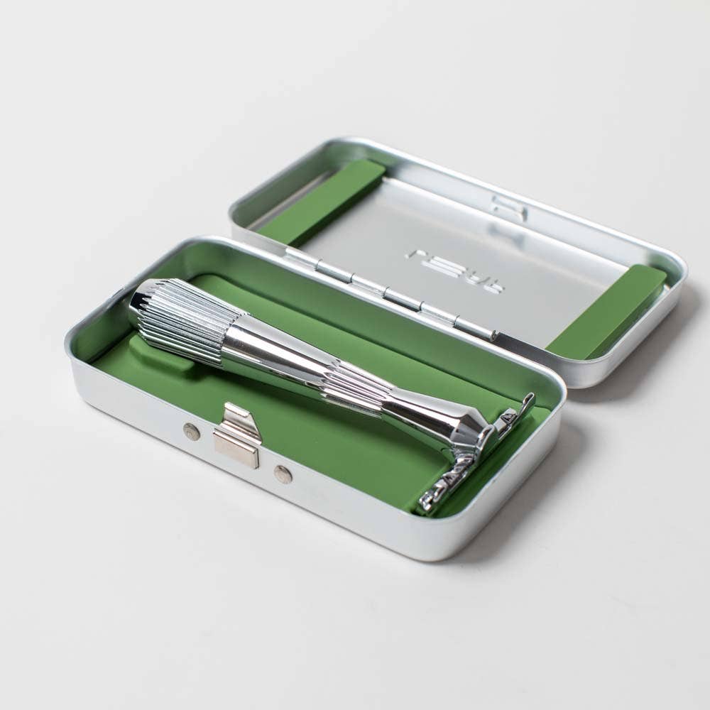 Silver razor in a green and silver case on a light gray background